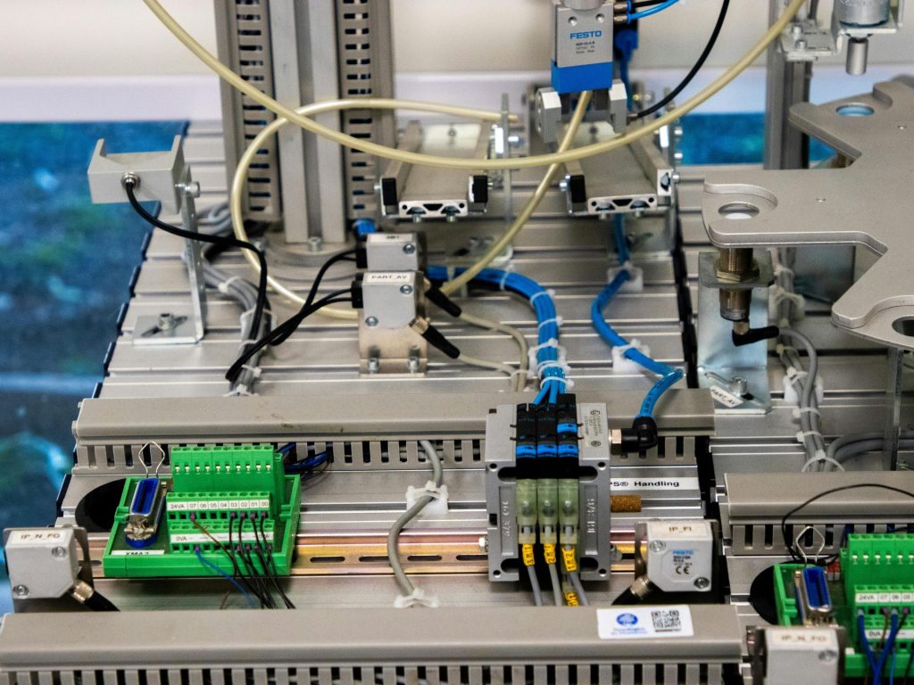 Nahaufnahme von Industrieanlagen mit elektronischer Verkabelung und Sensoren in einer Fertigungsumgebung.